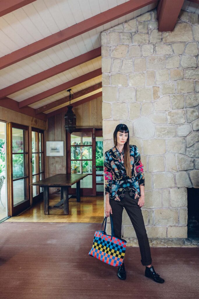 checkered bag paired with a patterned shirt modeled in a modern house 