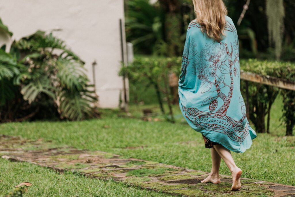 Donne in a beautiful turquoise shawl walking across her own yard